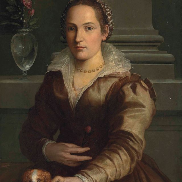 Alessandro Allori — Портрет дамы в полный рост, в платье цвета ржавчины и замысловатом головном уборе, с розой в правой руке, с собачкой, рядом с вазой с розами и подснежниками, в интерьере
